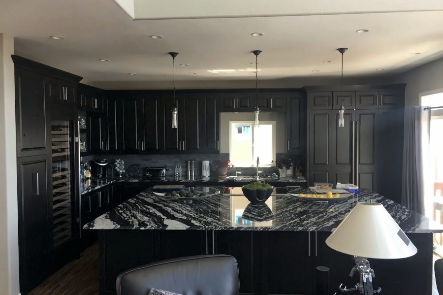 Matte black kitchen with veined stone island