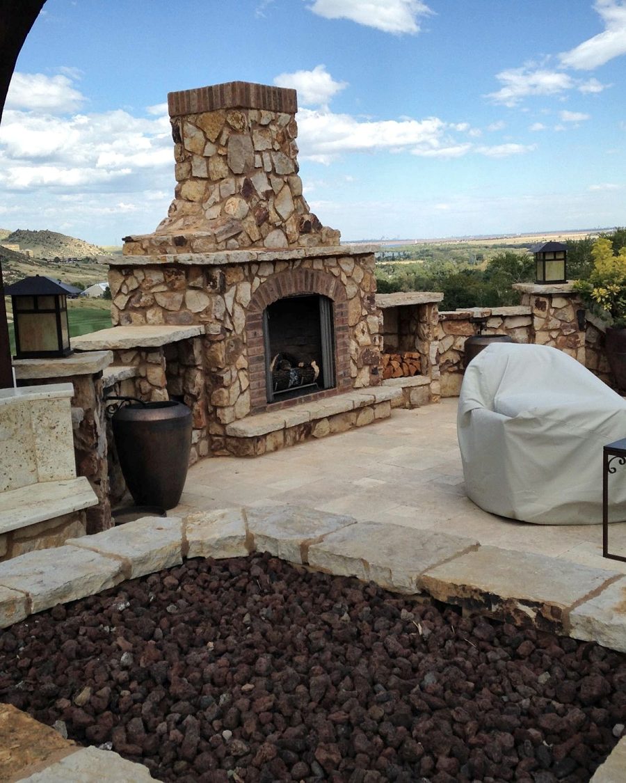 Stone patio with outdoor fireplace by Rhino Build