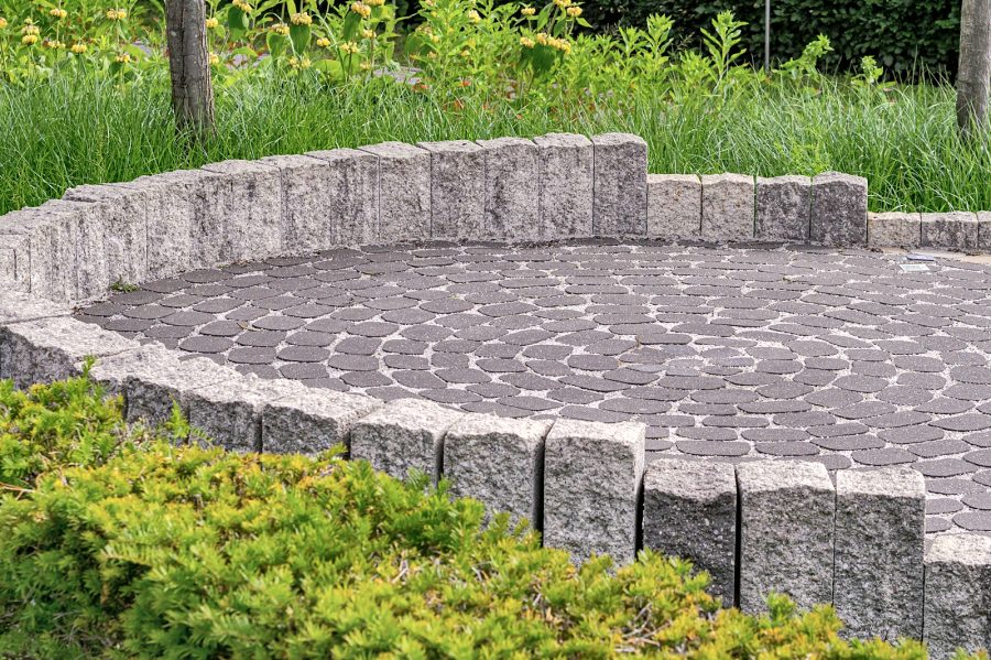 Paver patio framed by a stone retaining wall